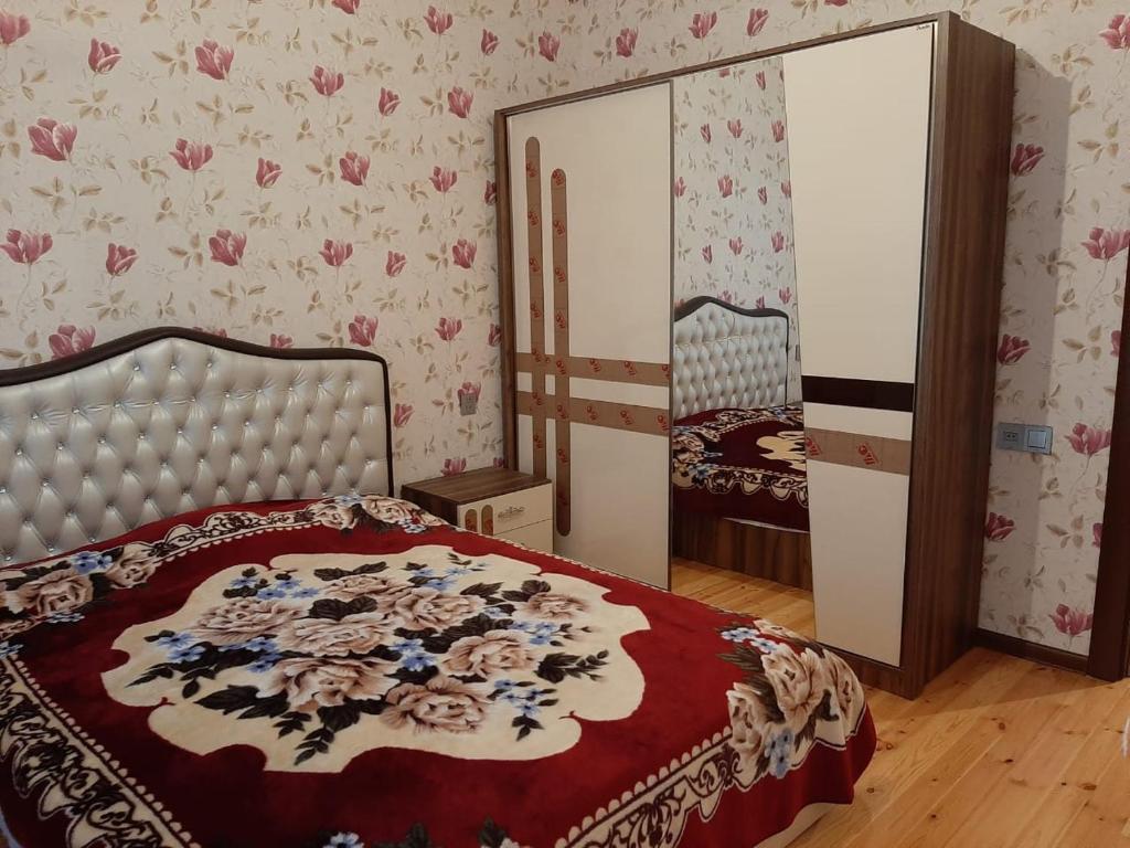 a bedroom with a bed and a large mirror at My sweet home in Ramana in Baku