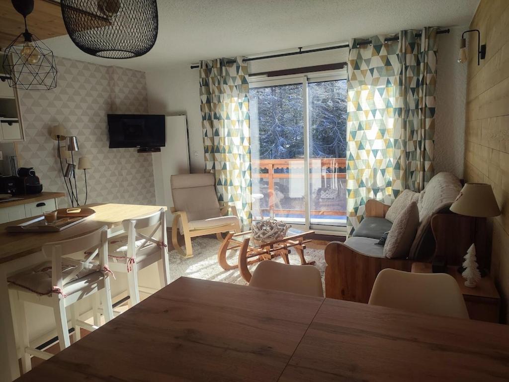 Hotel Studio 4-6 couchages.pied des pistes.Résidence Montana1, a living room with a table and a living room with a couch at Studio 4-6 couchages.pied des pistes.Résidence Montana1 in Les Deux Alpes