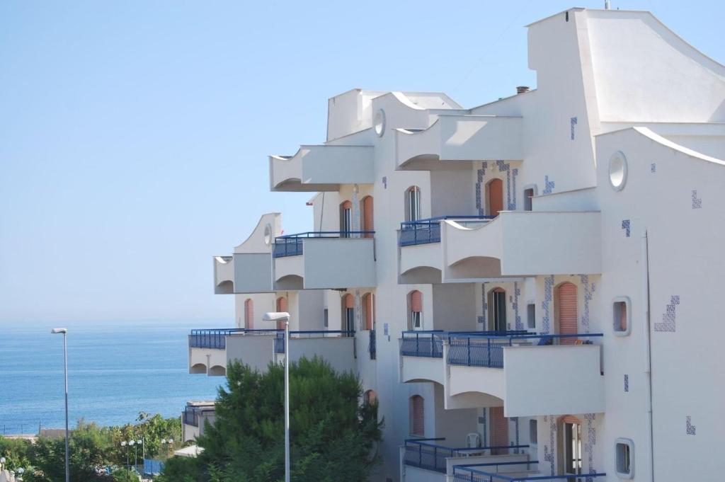 un edificio con balcones y el océano en el fondo en Residence Baia degli Sciti, en Torre a Mare