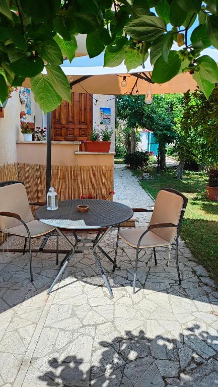 a table and chairs under an umbrella on a patio at GreenHouse_Anzio in Anzio