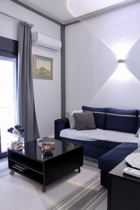 a living room with a blue couch and a coffee table at Beautiful Apartment in Corfu in Agios Rokkos