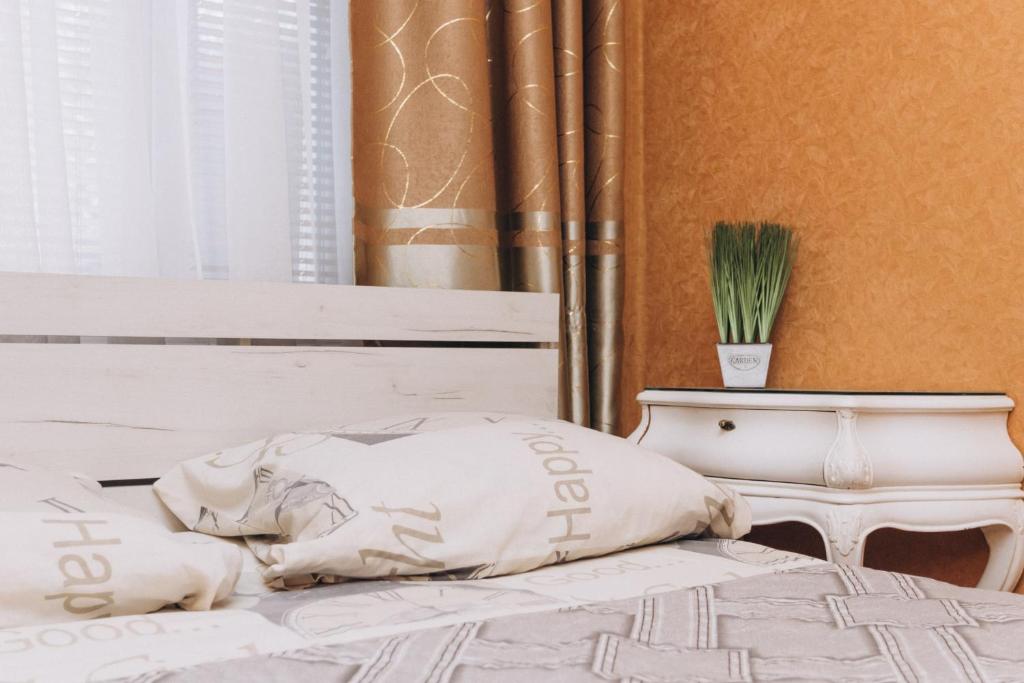 un letto con cuscino bianco e un tavolo di Квартира в центре города a Sumy