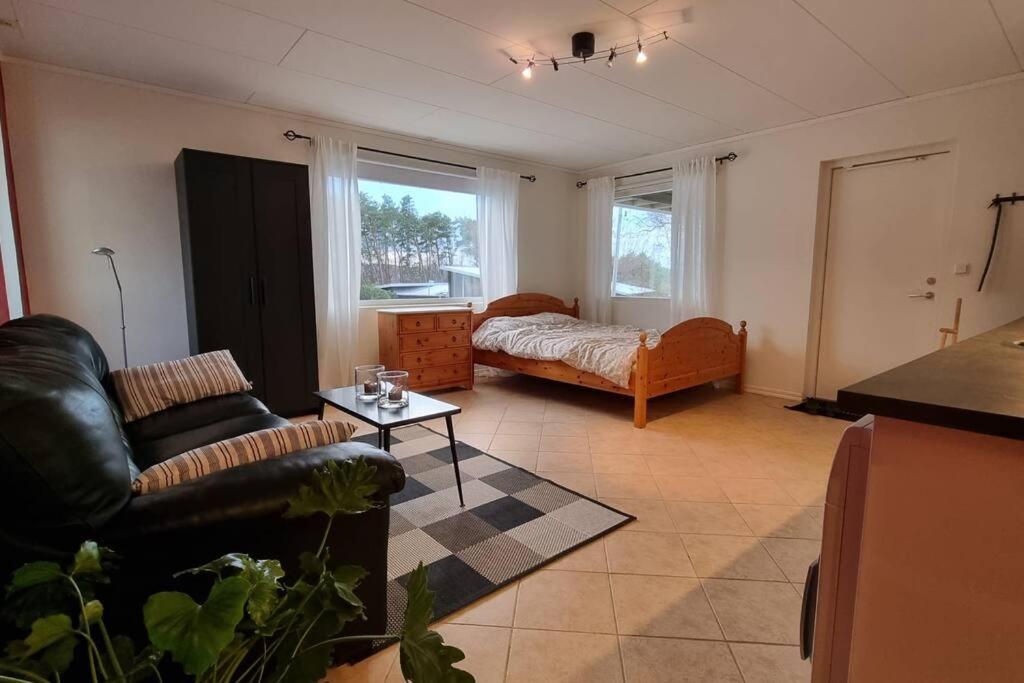 - un salon avec un canapé et un lit dans l'établissement Quiet and comfy with swimming pool, à Onsala