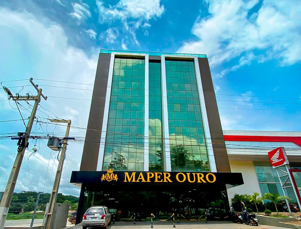 un gran edificio con un cartel delante en Maper Ouro, en Parauapebas