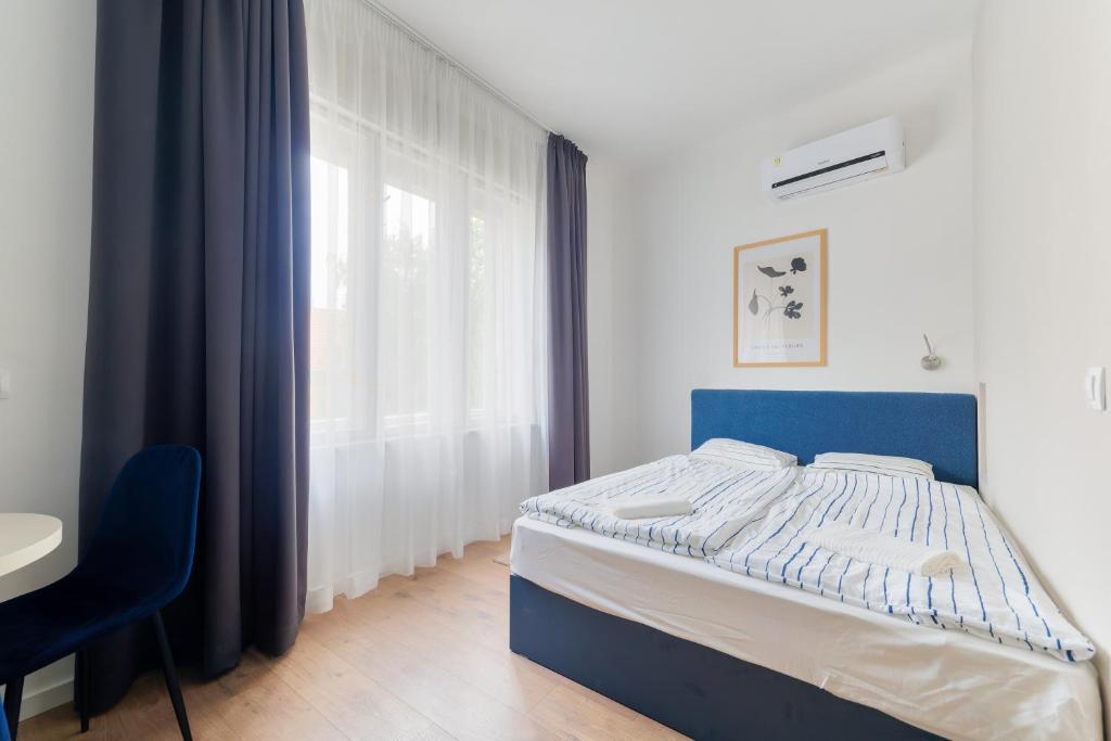 a bedroom with a blue bed and a window at Villa Oliver Budapest in Budapest