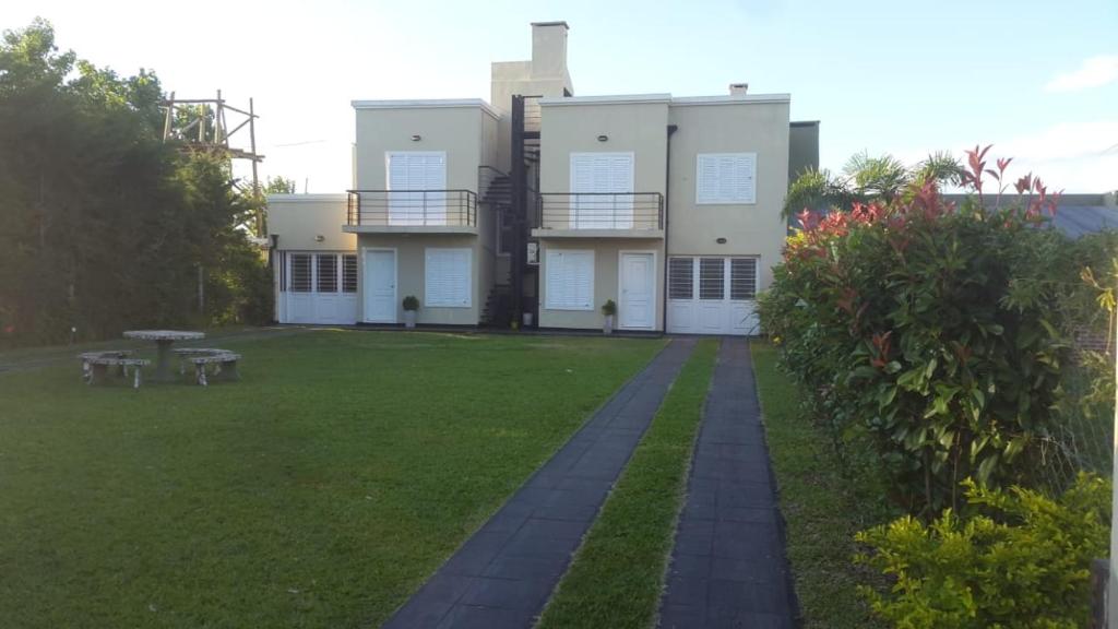 un gran edificio con un patio de césped delante de él en Departamentos Blanc en Colón