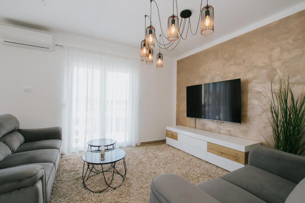 a living room with a couch and a tv at Royal Blue House 3 in Kaštela