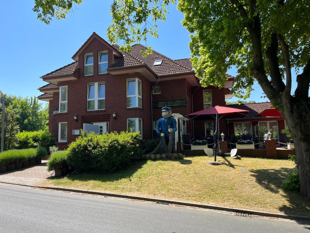 a large house with a statue in front of it at Hotel Nordwind in Lohme