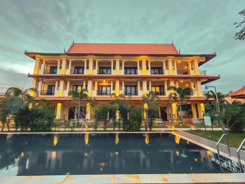 a building with a pool in front of it at Savada Angkor Boutique Hotel in Siem Reap
