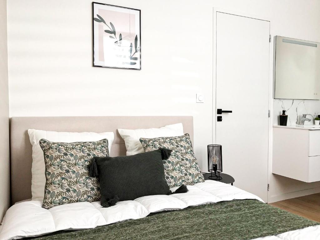 een slaapkamer met een bed met 2 kussens erop bij Le Tropical - Beau logement centre - Gare - Tram in Le Mans