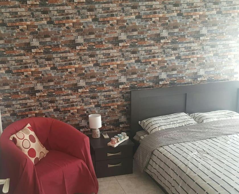 a bedroom with a bed and a red chair at Serres citycenter.Free parking place in 100m in Serres