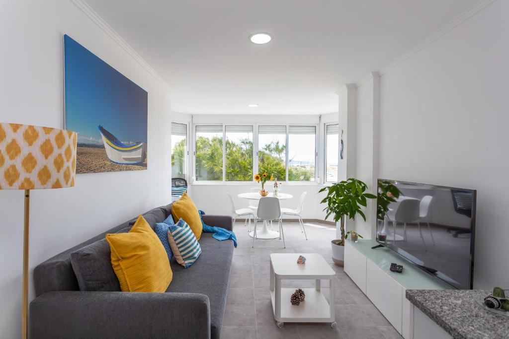 a living room with a couch and a tv at BeGuest Beachfront Apartment Caparica Lisbon in Costa da Caparica