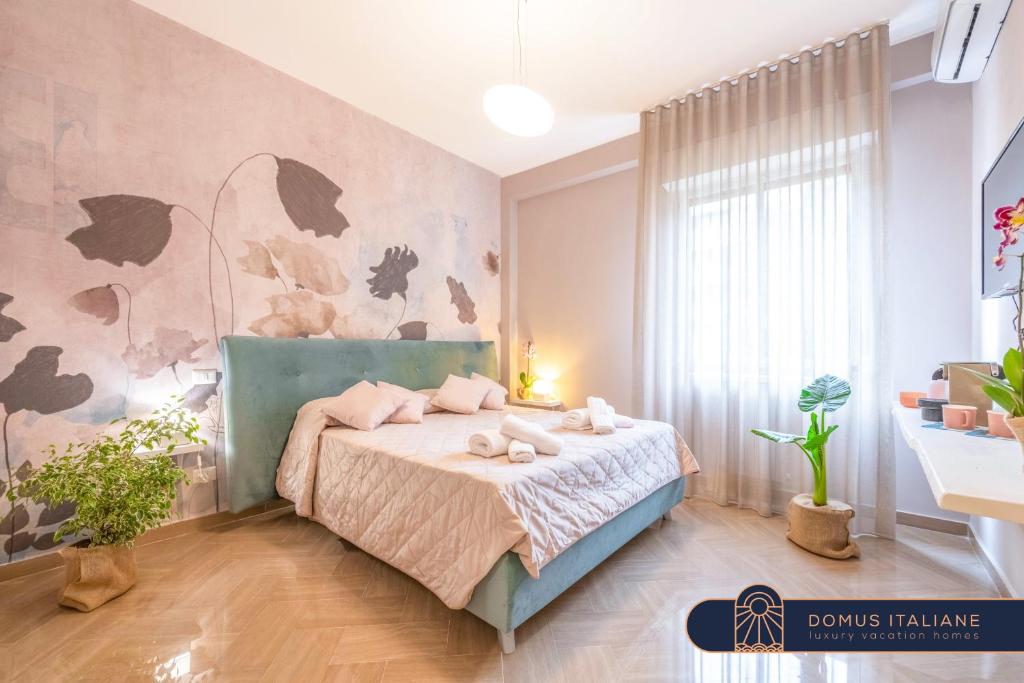 une chambre avec un lit avec des oreillers roses dessus dans l'établissement City Gate - luxury suites, à Bari