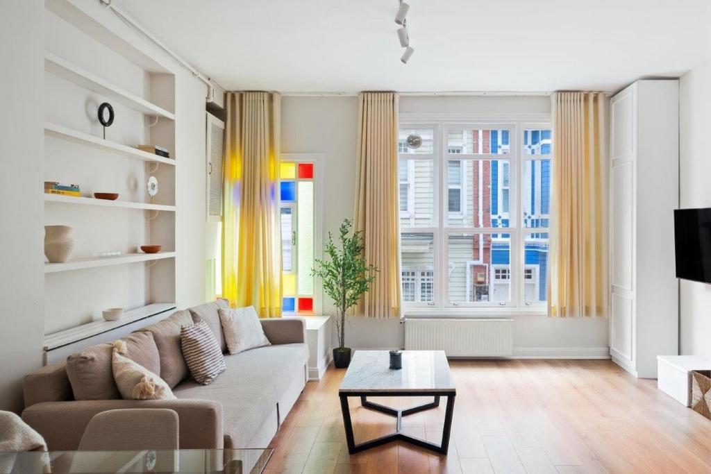 uma sala de estar com um sofá e uma mesa em Charming Bright Modern Design 1bd Home #282 em Istambul