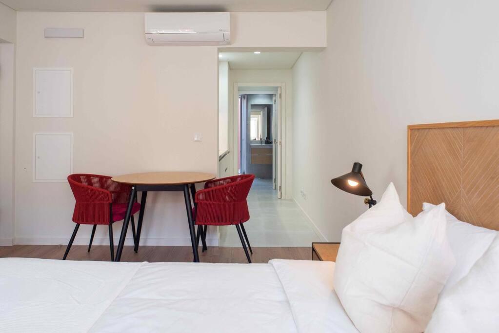 1 dormitorio con 1 cama, mesa y sillas en Pardal RC B - Stylish Studio in Alcantara with free parking nearby, en Lisboa