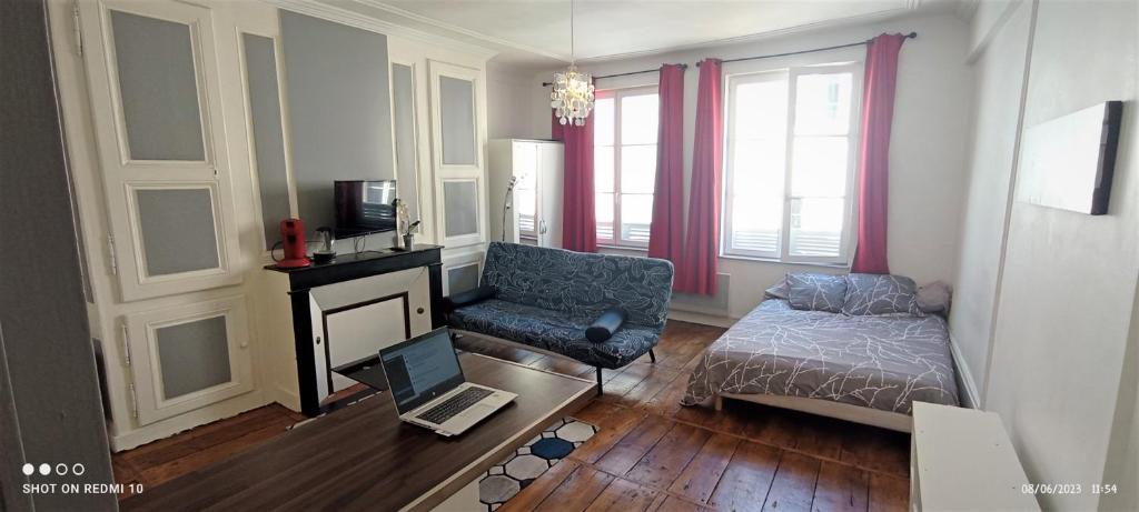 - un salon avec un canapé et une table avec un ordinateur portable dans l'établissement STUDIO cosy dans le centre de LIMOGES, à Limoges