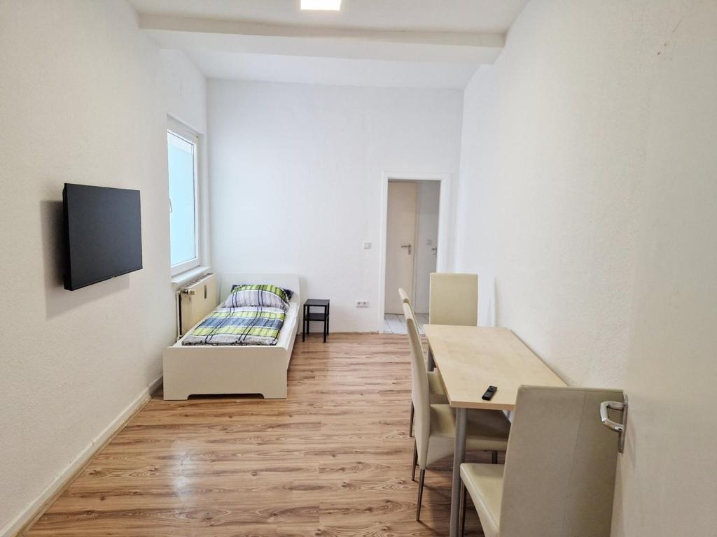 Cette chambre comprend une table, un lit et une salle à manger. dans l'établissement Work & Stay Apartments in Leverkusen, à Leverkusen