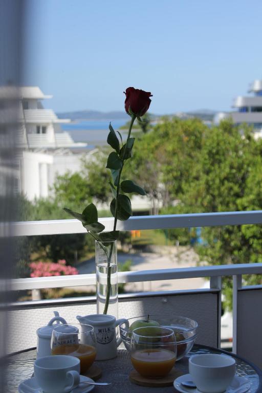 a vase with a rose in it sitting on a table at Charlie Apartments in Vodice
