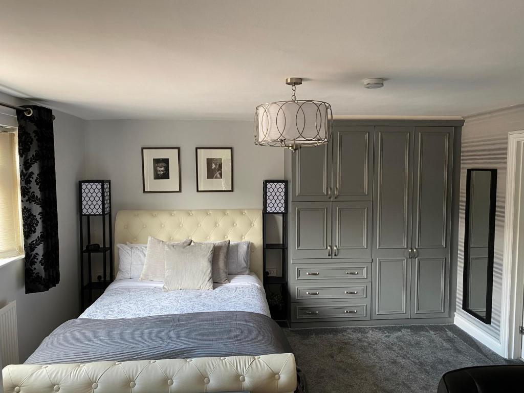 a bedroom with a bed and a chandelier at Hansom House in Hinckley