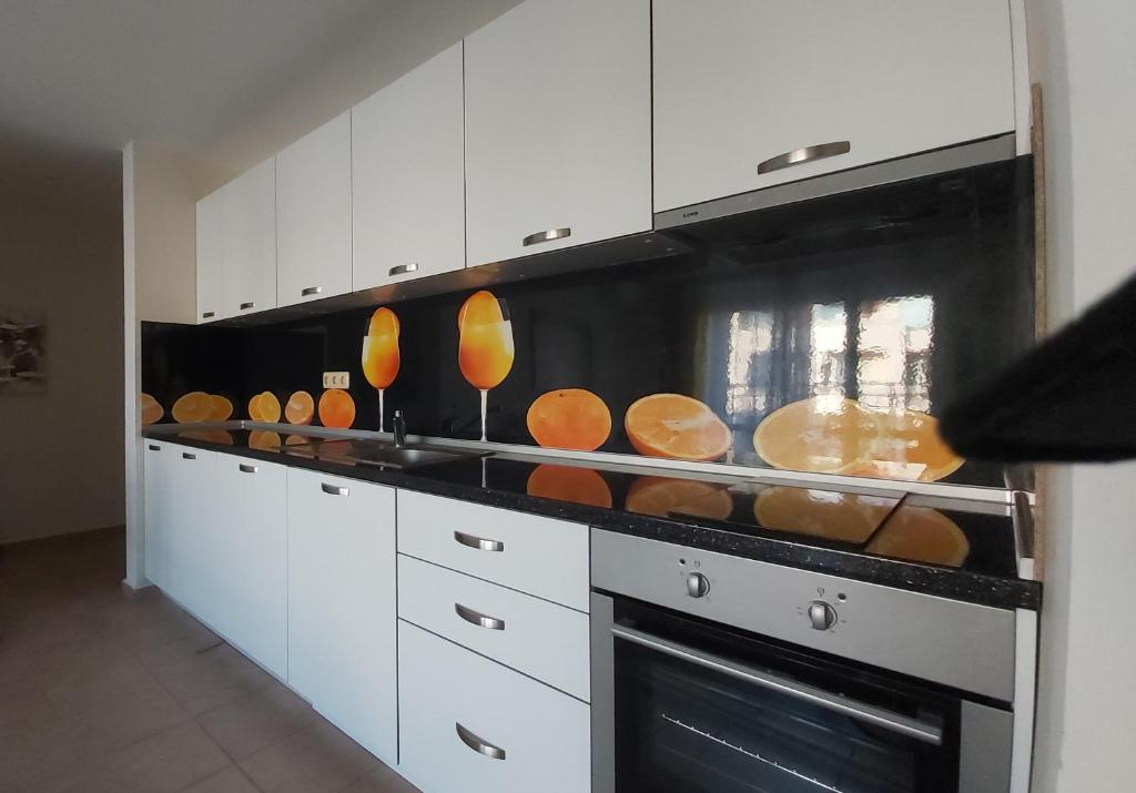 a kitchen with white cabinets and a stove with pans at 2 Zimmer Wohnung in Sunny Beach
