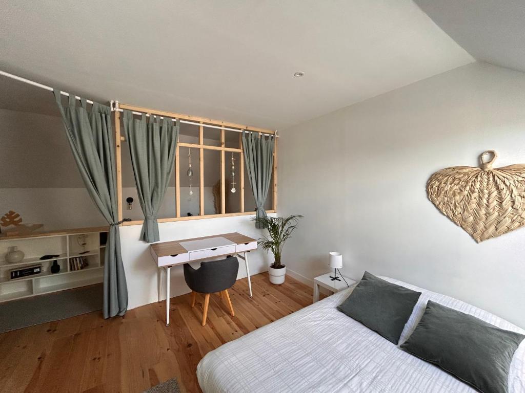 a bedroom with a bed and a desk at Le ker Maclow in Saint Malo
