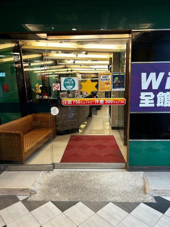 een glazen deur van een winkel met een bank erin bij Tong Bing Express in Hsinchu City