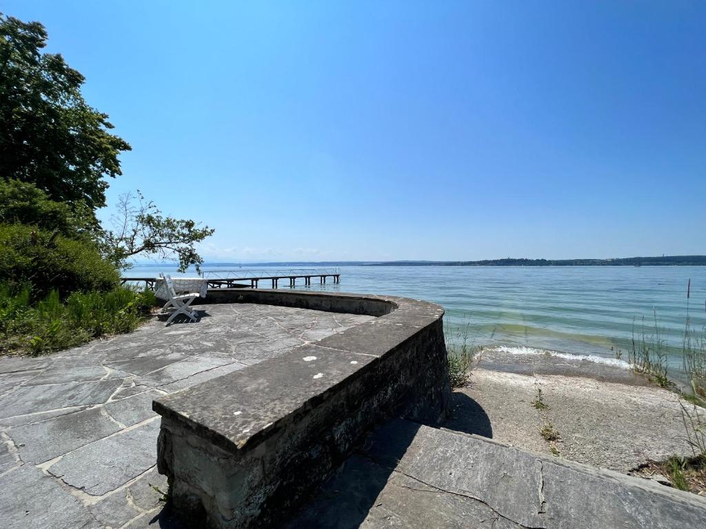 a stone bench next to a body of water at Landhaus am See mit privatem Seezugang in Meersburg