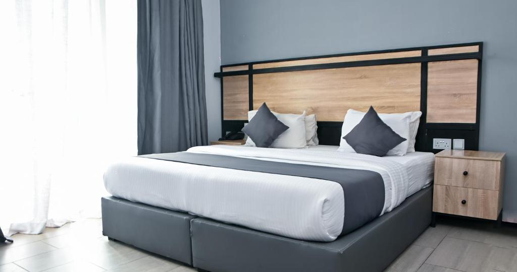a bedroom with a large bed with white sheets and pillows at The Blowfish Hotel in Lagos