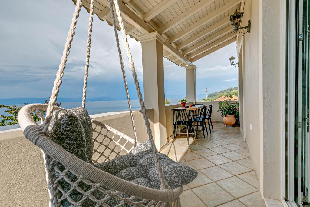a swing on the porch of a house at Gialos Holiday House in Agia Pelagia Chlomou