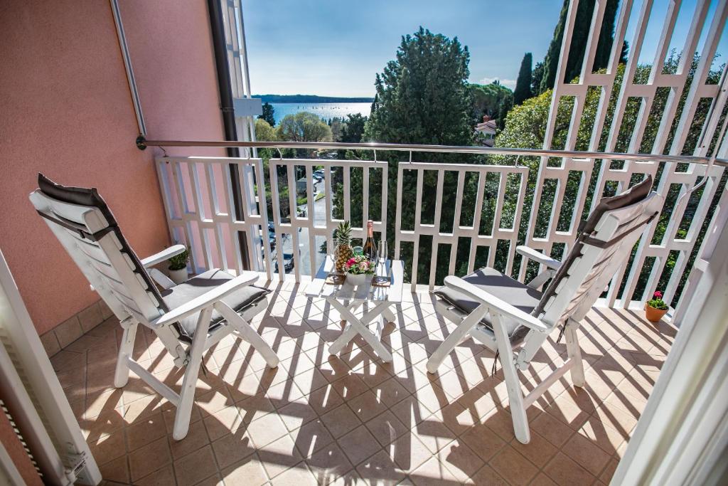 twee witte stoelen op een balkon met uitzicht bij Sea & Me, pleasant seaside home in Portorož