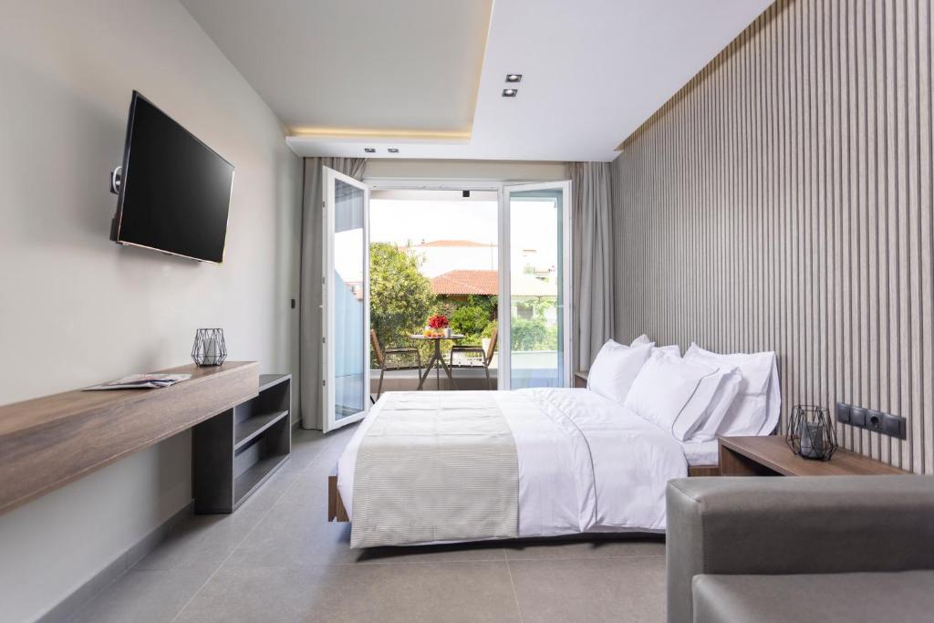 una camera d'albergo con letto e TV di Notos Premium Holiday Apartments a Pefkohori