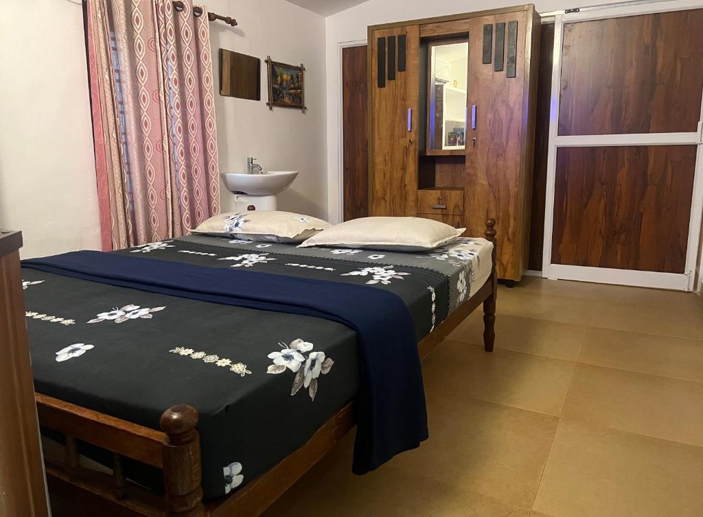 ein Schlafzimmer mit einem Bett und einem Waschbecken darin in der Unterkunft Cherai Beach Retreat in Cherai Beach