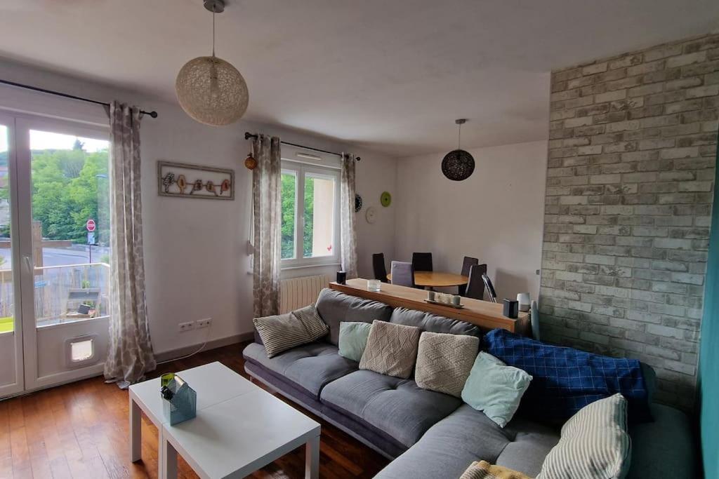 sala de estar con sofá y pared de ladrillo en Appartement Cocooning, en Ars-sur-Moselle