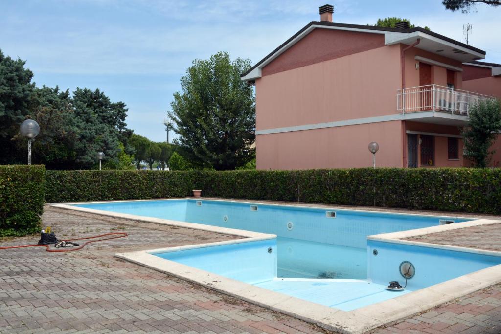 uma piscina em frente a uma casa em Appartamento Climatizzato con Piscina Ca' Aurelia em Lido di Savio