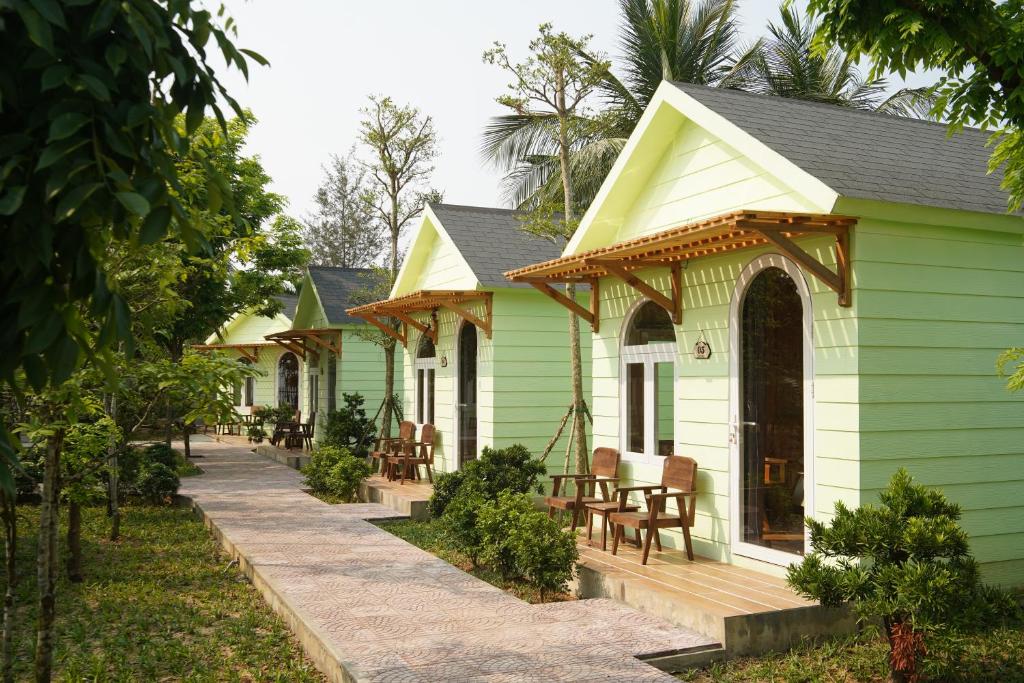 a green house with a porch and a deck at BH Villa Lăng Cô Huế in Lang Co