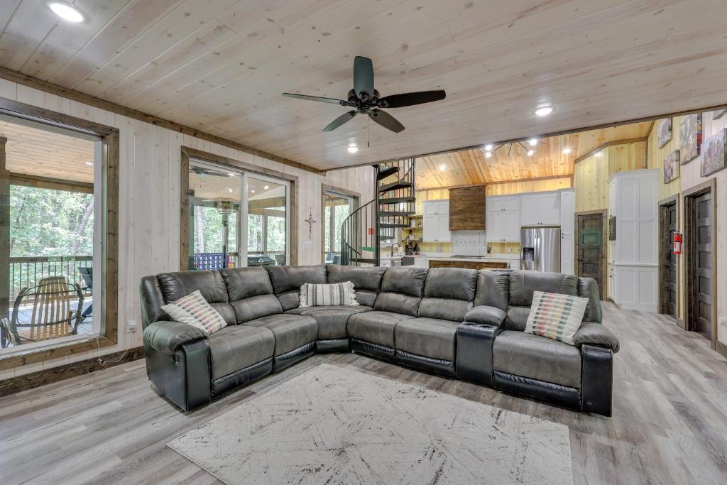 a living room with a couch and a ceiling fan at Family-Friendly Broken Bow Home with Deck and Grill! in Broken Bow