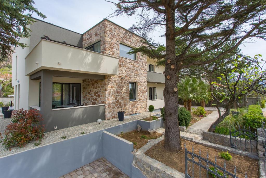 a house with a tree in front of it at Apartments Memories in Baška