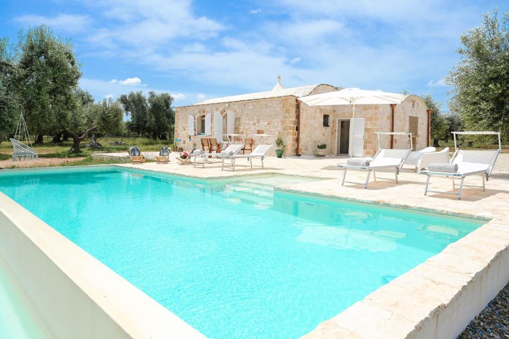 ein Pool vor einem Haus in der Unterkunft Trullo Delori with infinity Pool in Villa Castelli