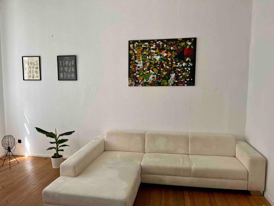 柏林的住宿－Wonderful flat near Ku’damm，客厅配有沙发和墙上的绘画