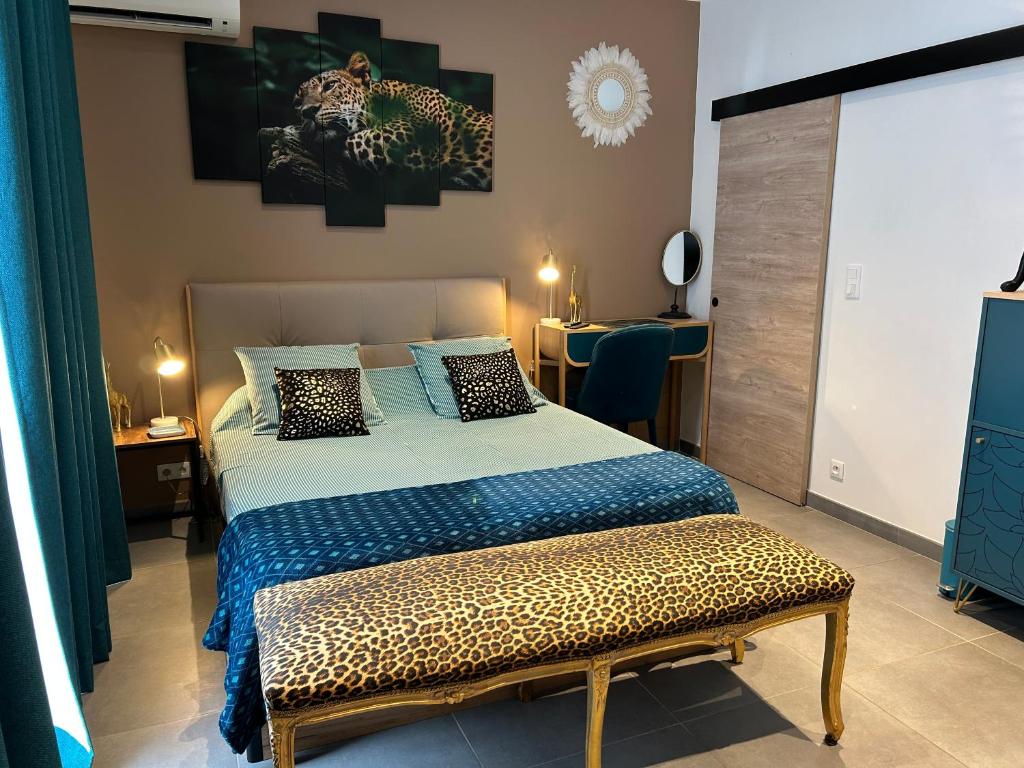 Dormitorio con cama con banco de estampado de leopardo en La CORSA CHAMBRE FAMILIALE DELUXE, en Narbona