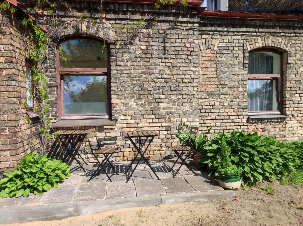 a brick building with two windows and two chairs at St.Pauls apartment in Riga