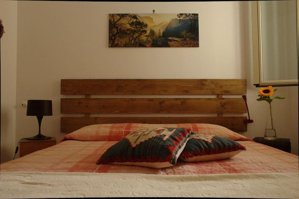 um quarto com uma cama e uma cabeceira em madeira em Casa Arcobaleno em Marsala