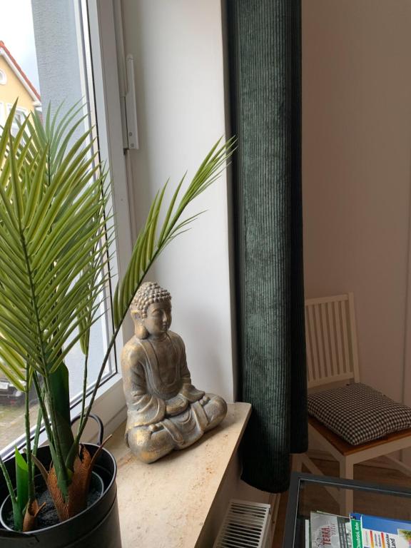 una estatua sentada en una mesa junto a una planta en Katharina Boardinghouse, en Osnabrück