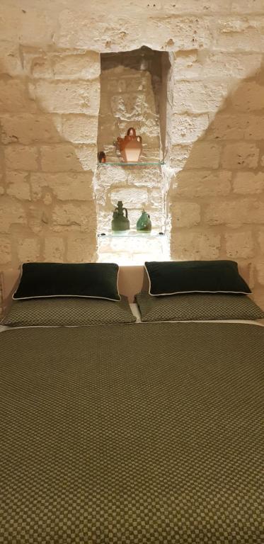 Bett in einem Zimmer mit einer Steinmauer in der Unterkunft Nicola's House Luxury Loft in Bari