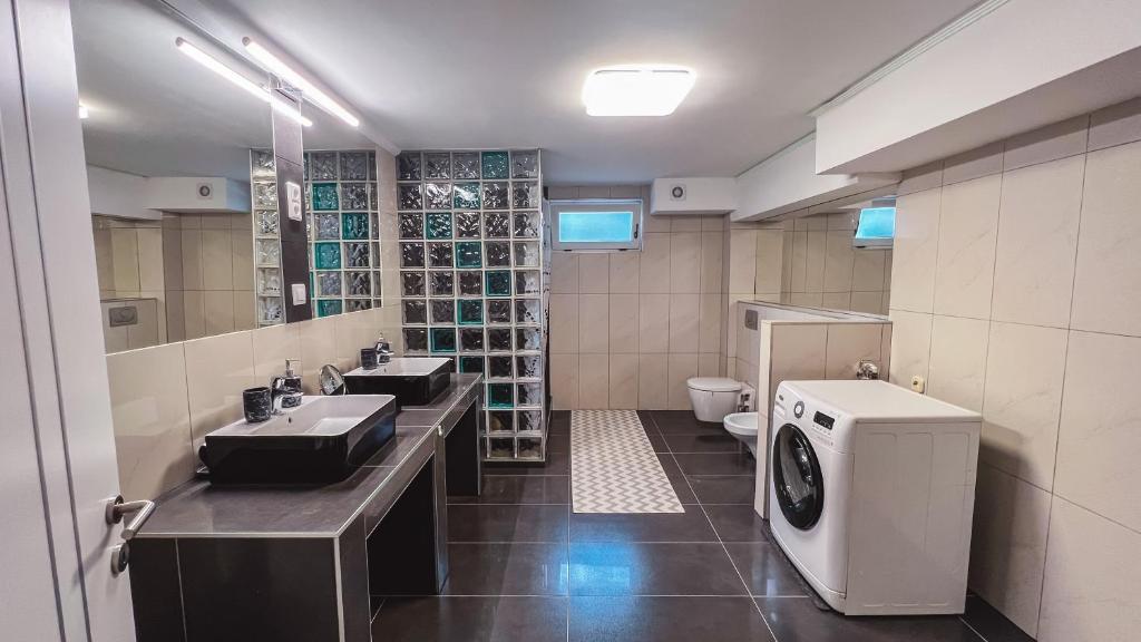 a bathroom with two sinks and a washing machine at Cozy Apartman in Leisbach 