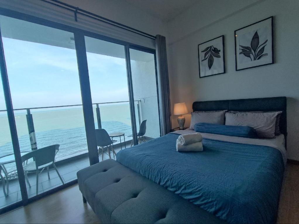 a bedroom with a bed and a view of the ocean at Kuantan Imperium seaview cityview by Avenzee in Kuantan
