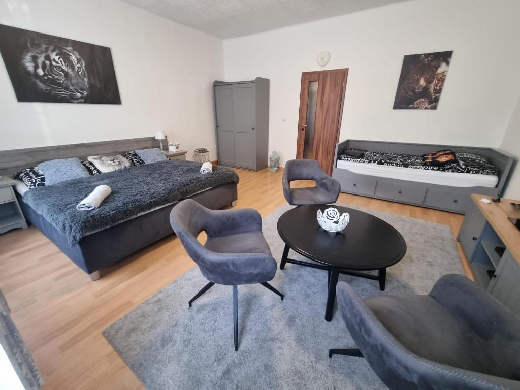 a bedroom with a bed and two chairs and a table at Apartmány Černý Tulipán 1 in Plzeň