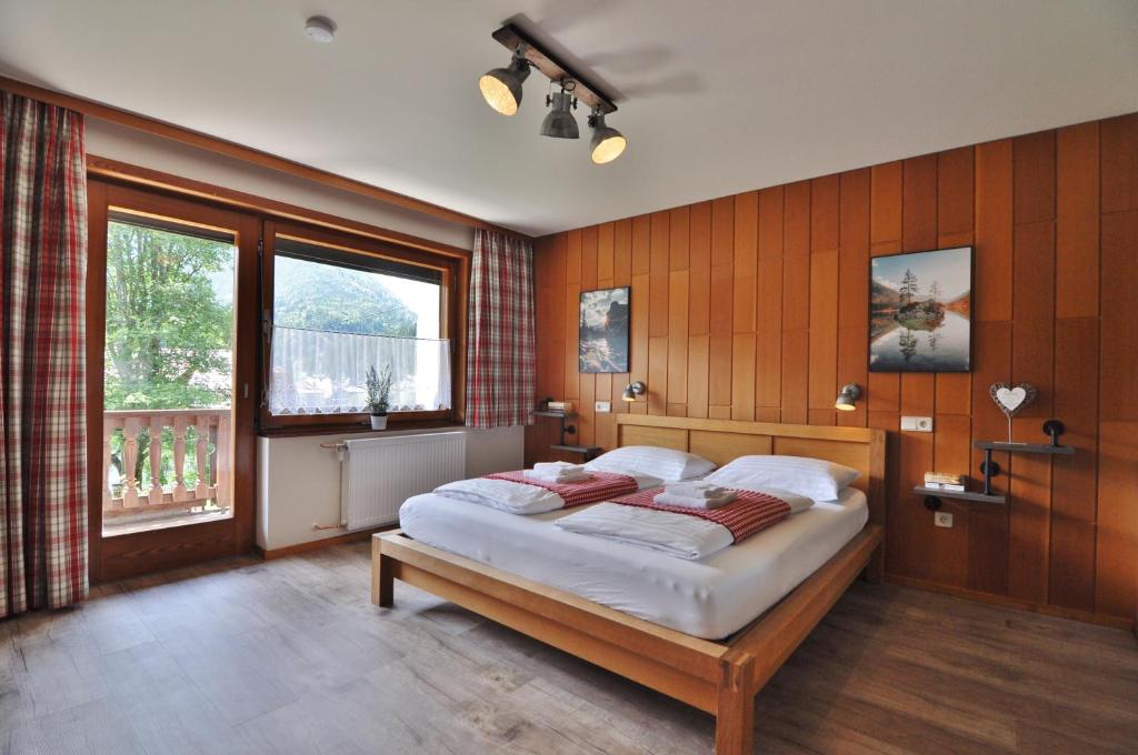 una camera da letto con un letto e una grande finestra di Pension & Apartments Weissbriach a Weissbriach