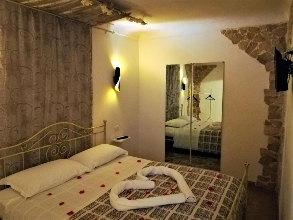 ein Schlafzimmer mit einem Bett und einem großen Spiegel in der Unterkunft SPA ROOM SICILIA in Rosolini