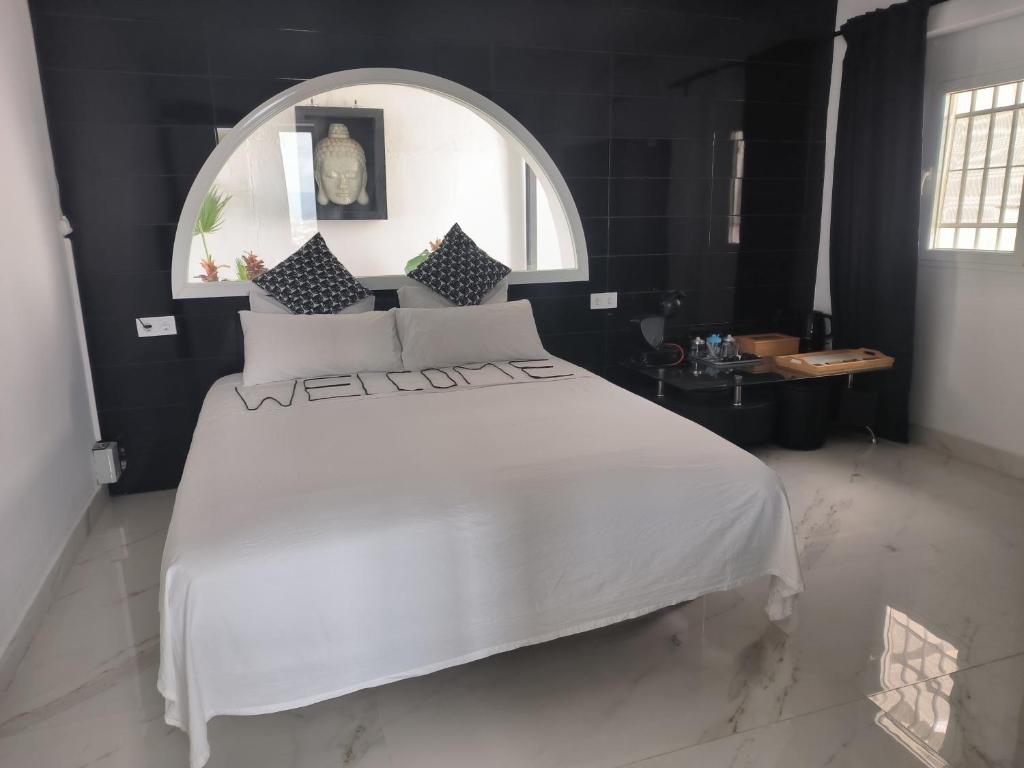 a bedroom with a large white bed and a mirror at Pinar Suites Loft in Torremolinos